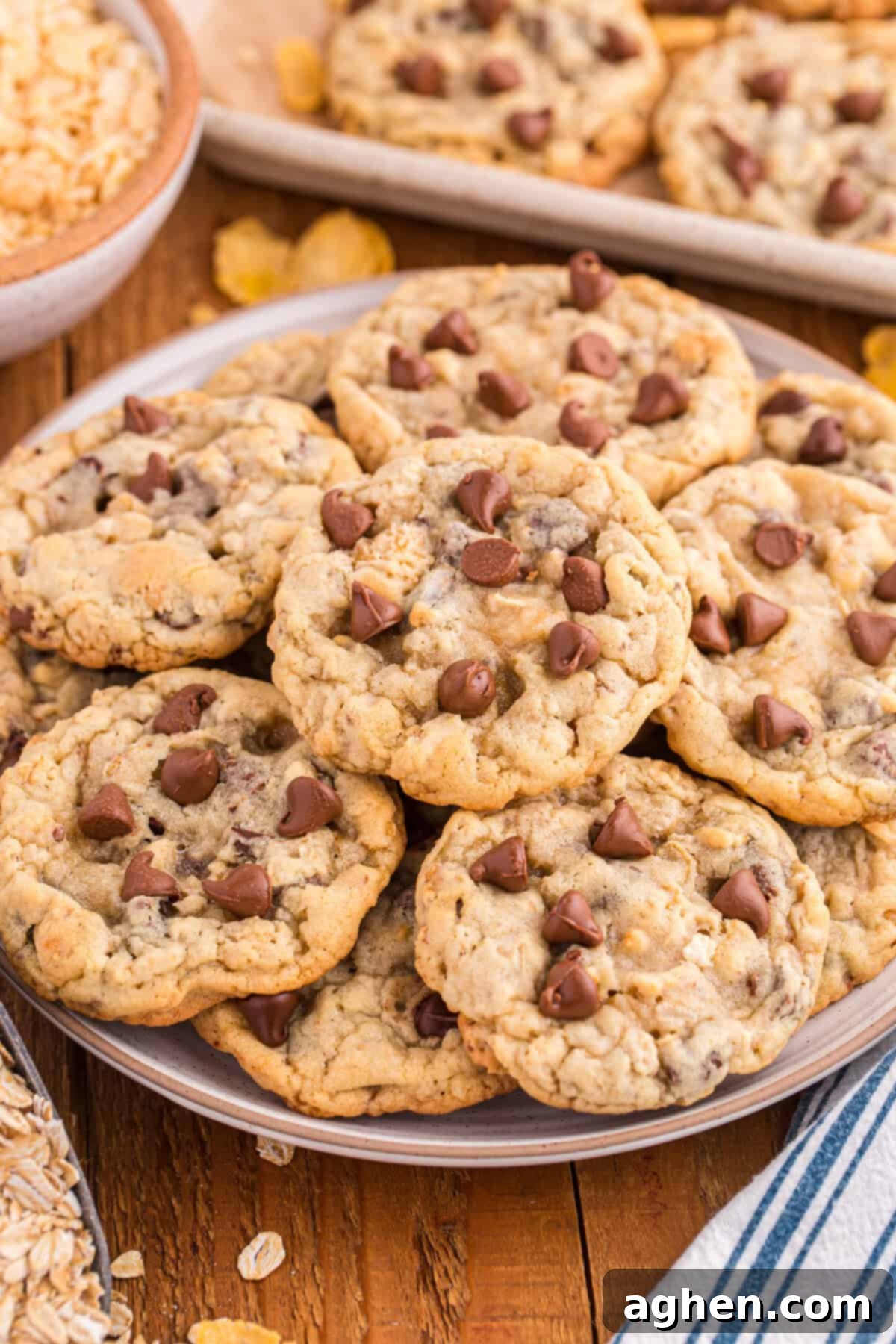 Plate filled with golden-brown Ranger Cookies featuring visible chocolate chips, oats, coconut, and cornflakes, emphasizing their rustic, hearty appearance and inviting mix of textures. Ideal for a classic cookie craving.