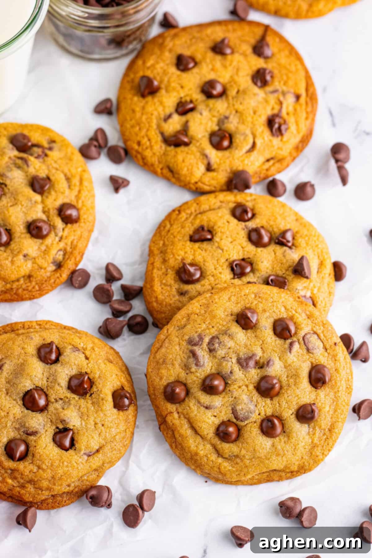 Bake Mrs Fields Legendary Chocolate Chip Cookies 3 A group of Mrs. Fields copycat chocolate chip cookies on parchment paper, surrounded by chocolate chips. These cookies are soft, chewy, and loaded with rich chocolate flavor.