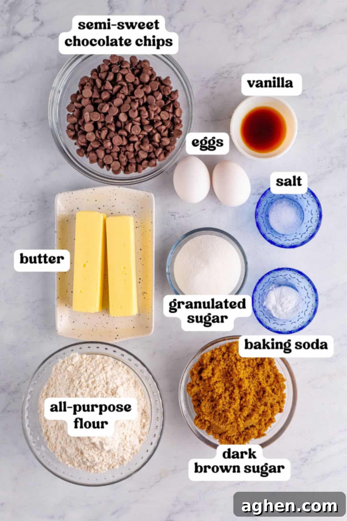 Bake Mrs Fields Legendary Chocolate Chip Cookies 4 Ingredients for the Mrs. Fields chocolate chip cookie recipe, including semi-sweet chocolate chips, butter, eggs, sugar, flour, and vanilla, labeled neatly on a marble surface.