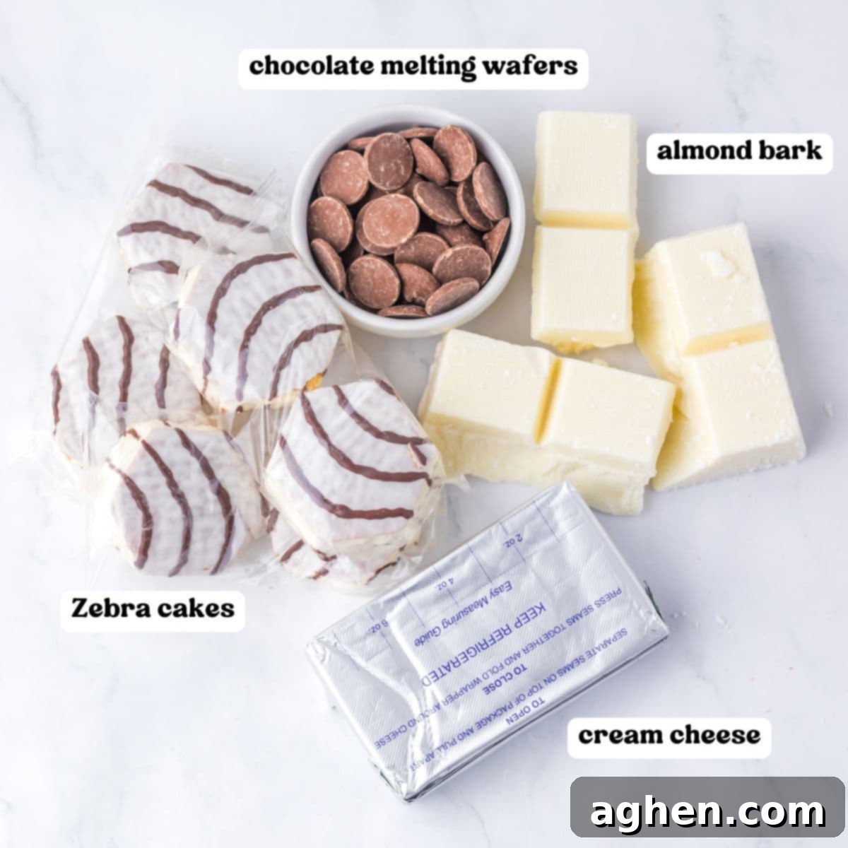 Zebra cakes, chocolate melting wafers, vanilla almond bark, and cream cheese on a white surface, each labeled.