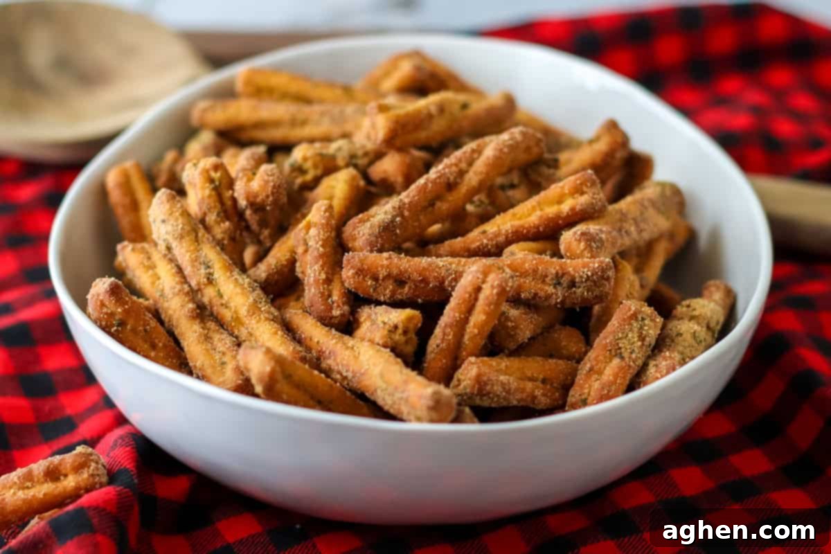 Spiced Pretzel Rods 7 A white bowl filled with perfectly seasoned pretzel twists, showcasing their crisp texture and uniform spice coating, reminiscent of gourmet flavored pretzels.