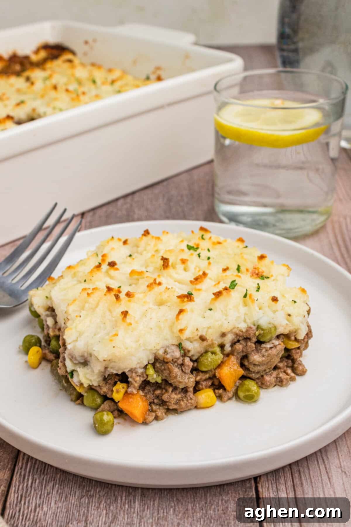 No-Fuss Cottage Pie 2 A plated slice of cottage pie on a white dish, showcasing the layered mashed potatoes and beef filling with vegetables.