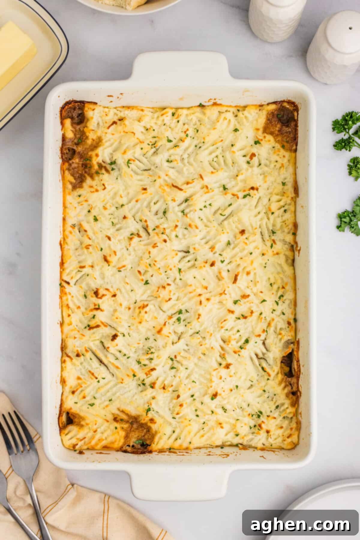 No-Fuss Cottage Pie 7 A baked cottage pie in a white casserole dish with a golden-brown mashed potato topping.