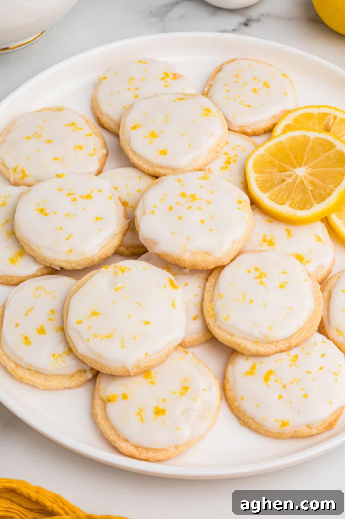 A plate of slice and bake lemon shortbread cookies with lemon glaze.