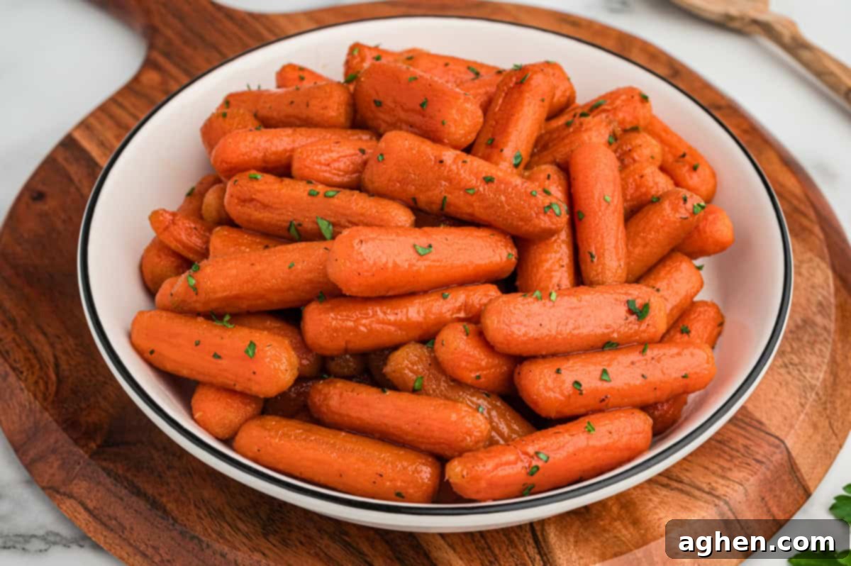 A bowl of glazed brown sugar baby carrots on a wooden serving board.