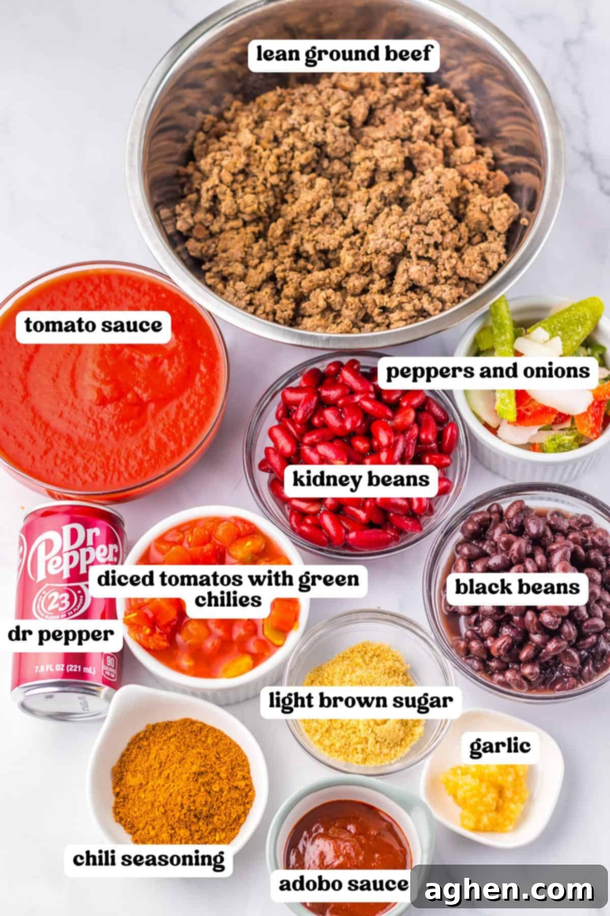 Ingredients for Dr Pepper chili, including ground beef, tomato sauce, kidney beans, black beans, peppers and onions, diced tomatoes with green chilies, light brown sugar, garlic, chili seasoning, adobo sauce and a can of Dr Pepper.
