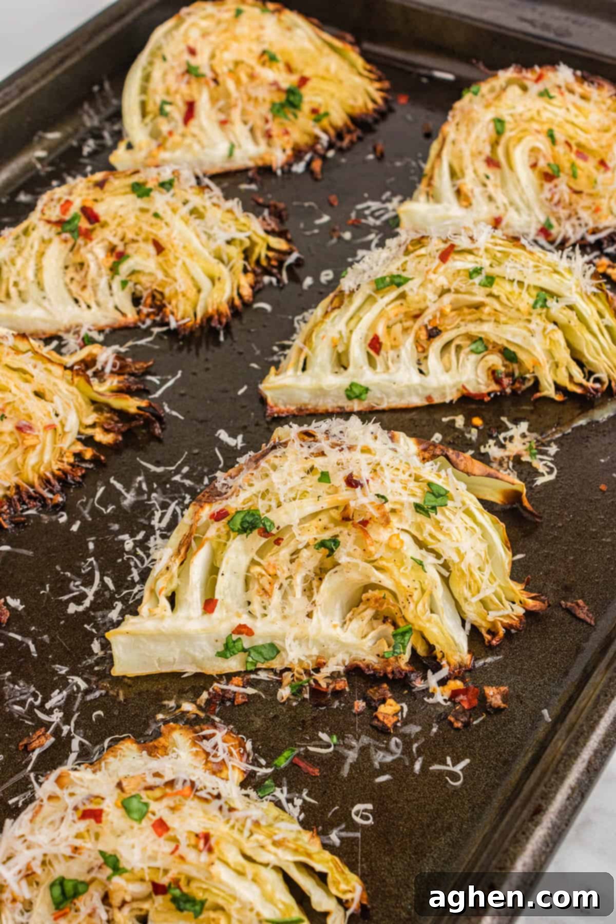 Golden Roasted Cabbage Wedges 3 Garlic parmesan roasted cabbage wedges on sheet pan.