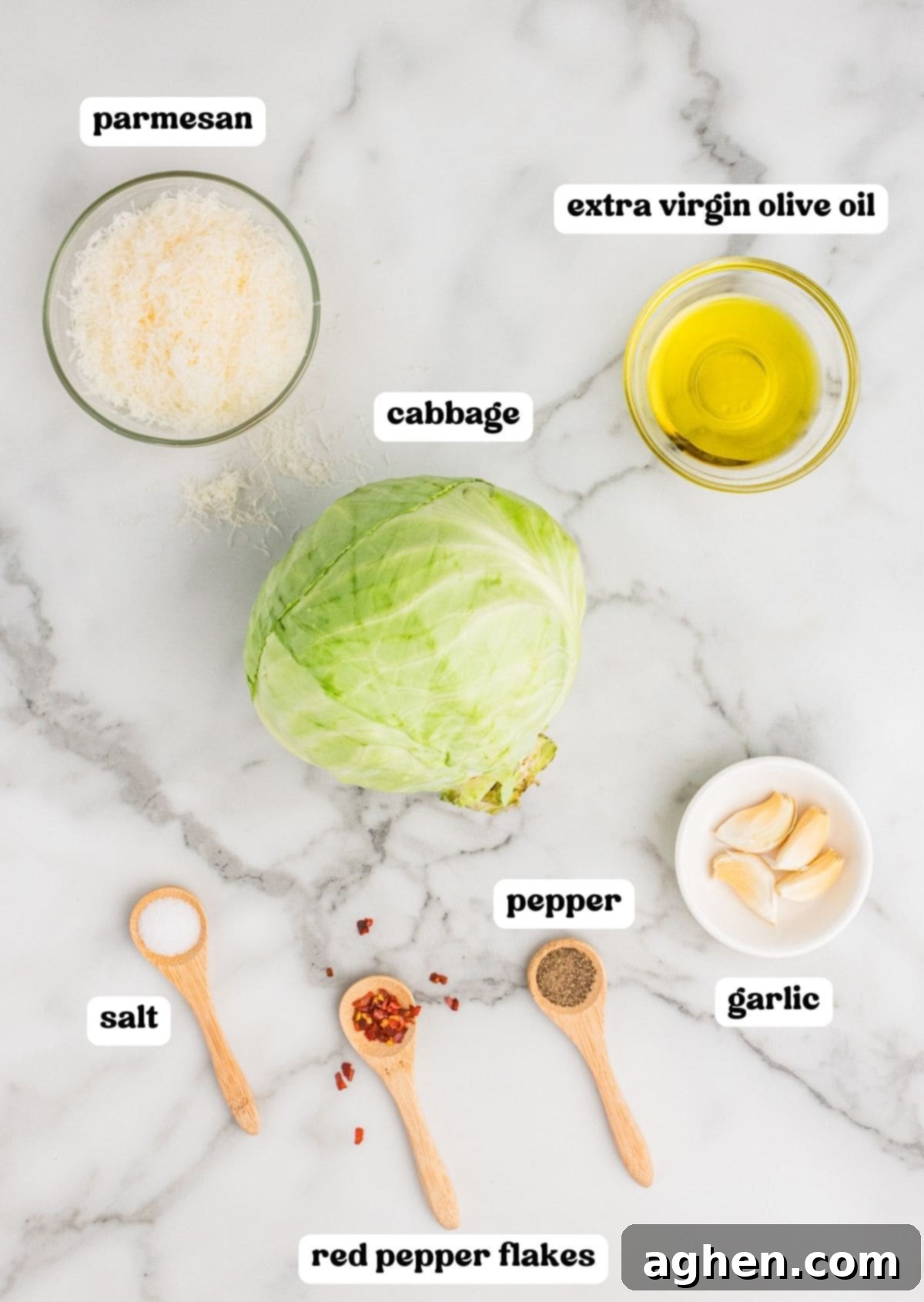 Golden Roasted Cabbage Wedges 4 Ingredients for roasted cabbage wedges on countertop: freshly grated parmesan, extra virgin olive oil, head of green cabbage, salt, pepper, red pepper flakes, and 4 garlic cloves.
