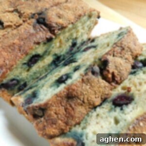 A close-up of the Cinnamon Blueberry Banana Bread, showcasing the golden-brown crust and moist interior.