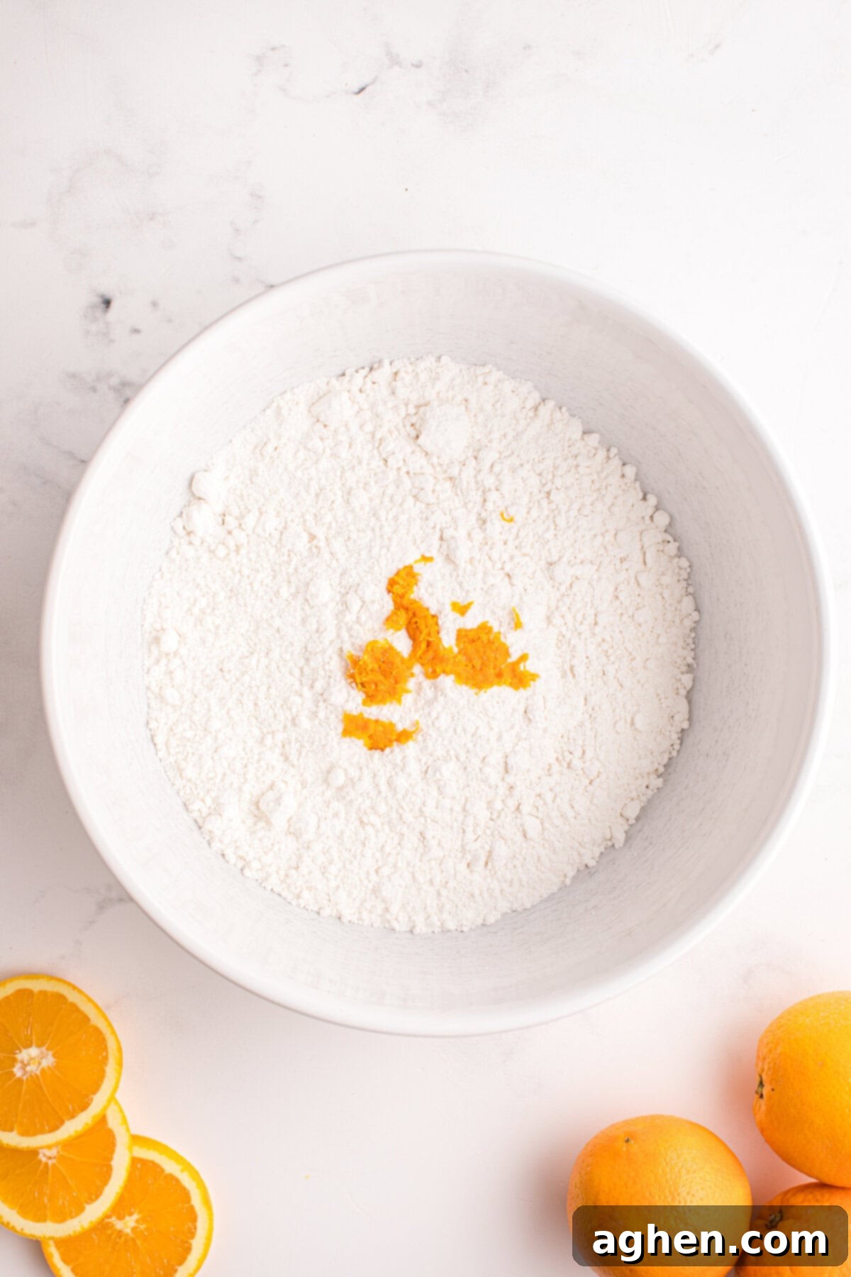 Bowl of dry ingredients with orange zest on top.