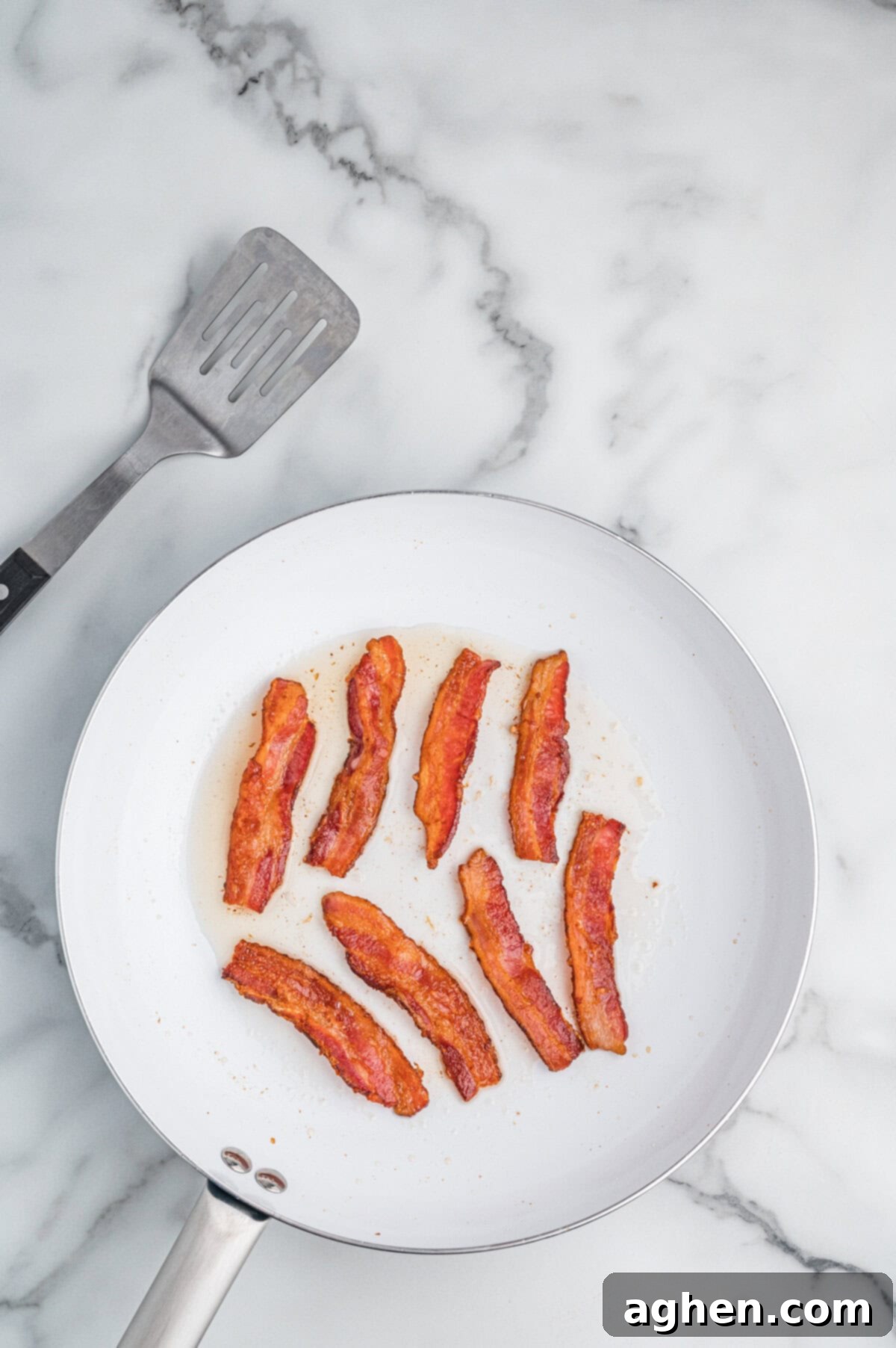 Skillet with cooked bacon strips.