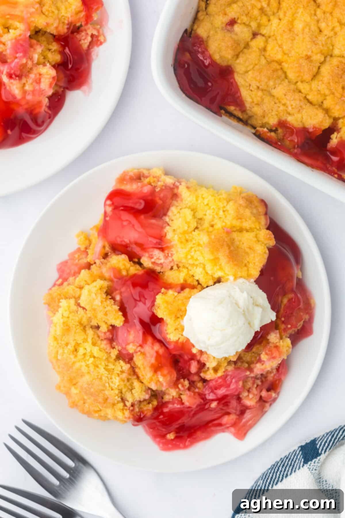 Easy Rhubarb Dump Cake 8 A plated serving of rhubarb dump cake, perfectly baked, topped with a luscious scoop of melting vanilla ice cream, showcasing the golden crust and fruity interior.