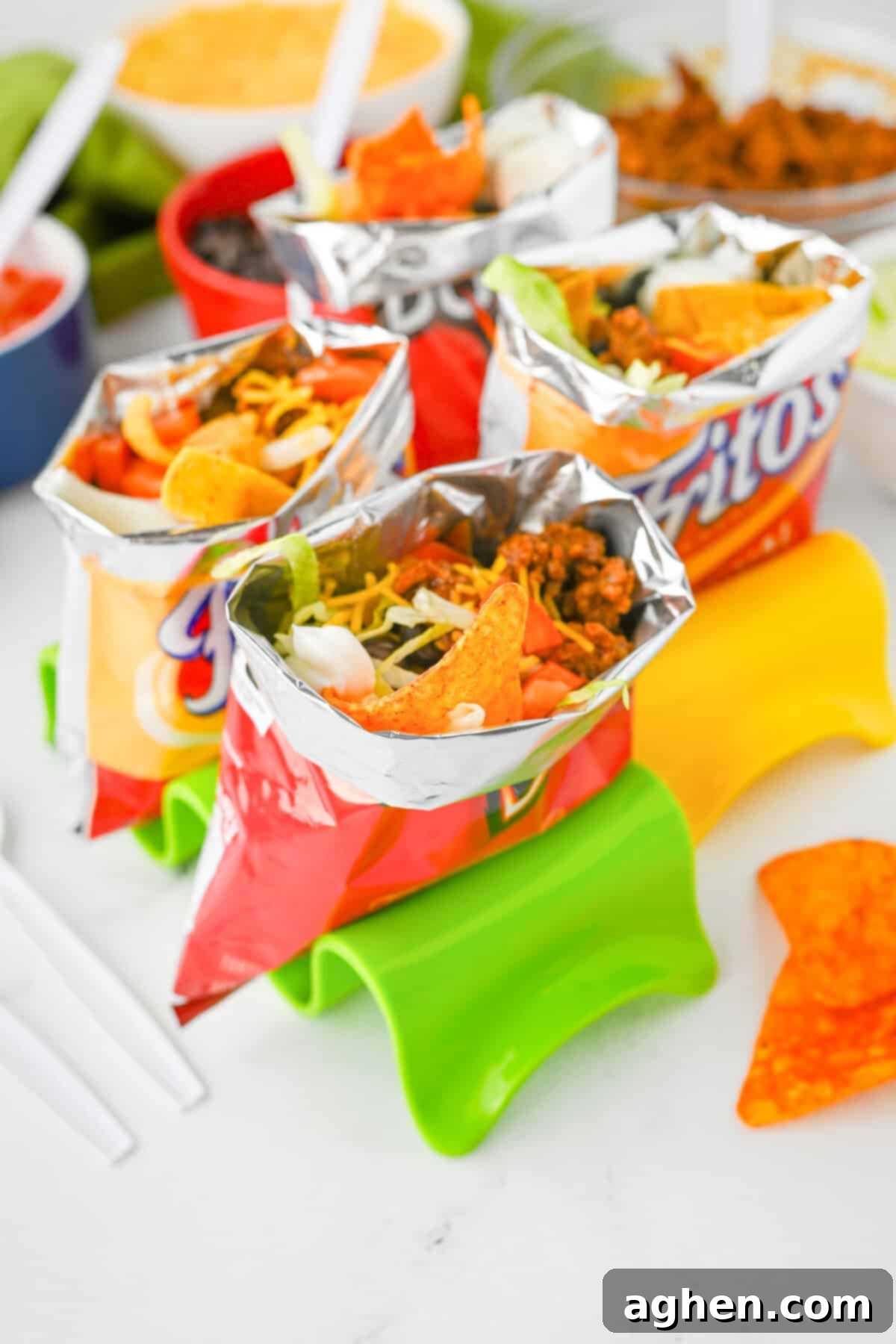 An inviting spread of multiple walking tacos, served in their original Fritos and Doritos bags, generously filled with seasoned ground beef, vibrant shredded cheese, chopped tomatoes, crisp lettuce, hearty black beans, and cool sour cream.