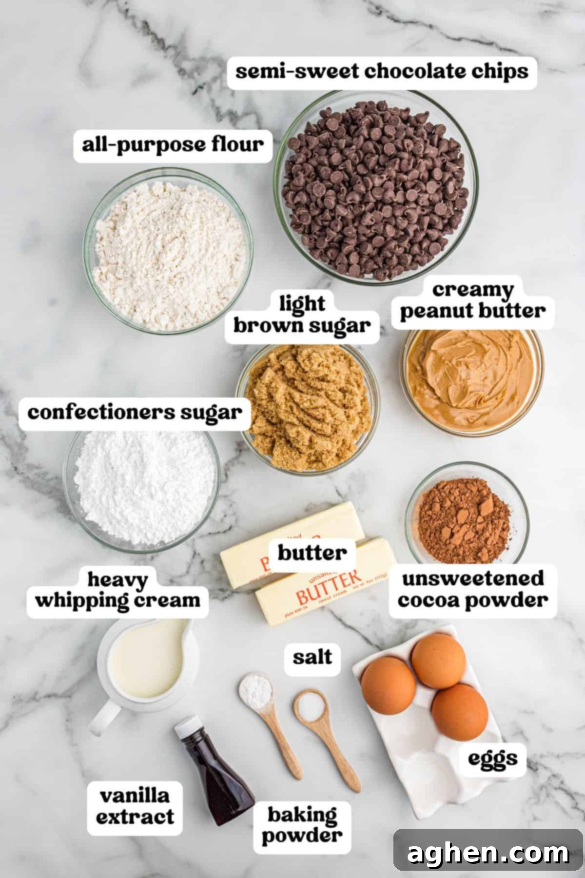 Overhead image of labeled ingredients for buckeye cookies, including semi-sweet chocolate chips, all-purpose flour, light brown sugar, creamy peanut butter, confectioners sugar, unsweetened cocoa powder, butter, heavy whipping cream, vanilla extract, salt, baking powder, and eggs.