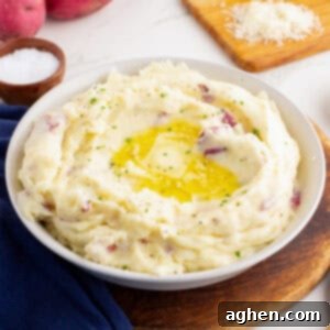 Bowl of red skin mashed potatoes with butter and herbs.