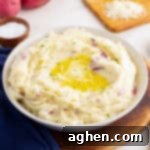 Bowl of red skin mashed potatoes with butter and herbs.