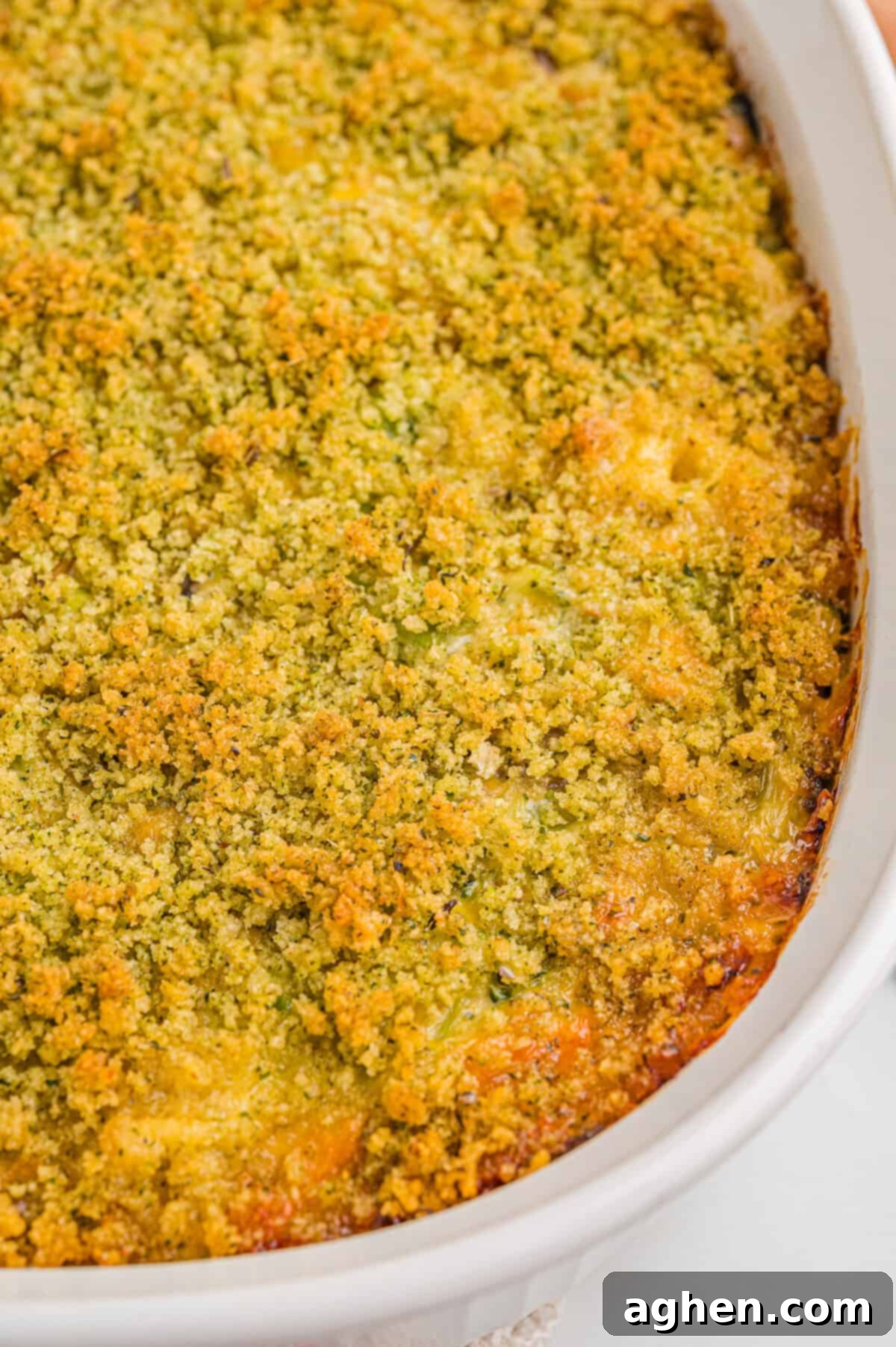 Cheesy Broccoli Delight 8 Overhead view of a freshly baked broccoli cheddar casserole in a white dish, with a uniformly browned breadcrumb and cheese topping.