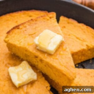 Slice of moist sweet potato cornbread with honey butter melting on top, a truly comforting treat.