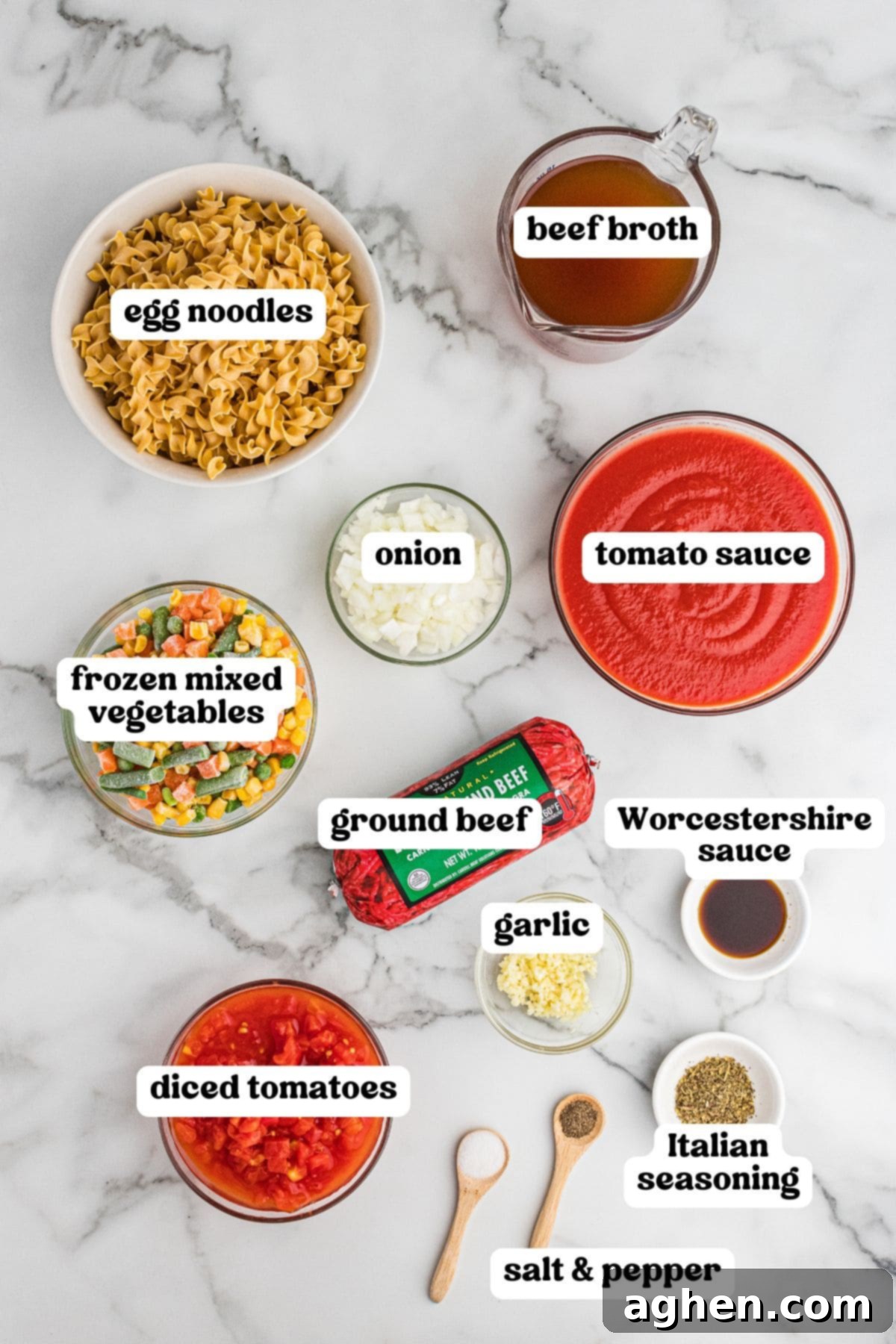 Ingredients for hamburger noodle soup, including egg noodles, ground beef, diced tomatoes, tomato sauce, beef broth, frozen mixed vegetables, onion, garlic, Worcestershire sauce, Italian seasoning, and salt and pepper.