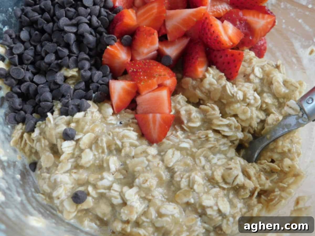 Close-up of ingredients for strawberry oatmeal muffins including oats, strawberries, and chocolate chips