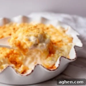 Golden Cheesy Creamed Corn Bake 2 Cheese corn casserole in white dish, ready to be served