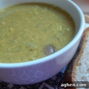 Creamy Coconut Chicken Curry Soup 2 A top-down shot of the finished Chicken Coconut Curry Soup in a white bowl with a spoon, garnished.