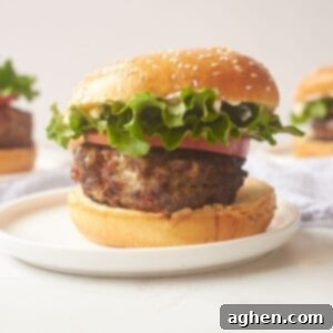 Unconventional Chicken Burgers 2 A delectable cracked chicken burger served on a white plate, showcasing the golden-brown patty, melted cheese, and fresh ingredients.