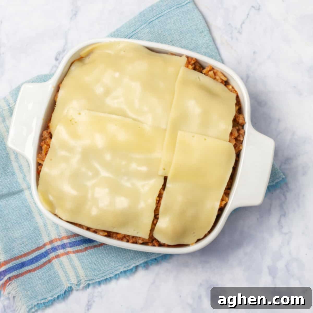 Quick-Fix Stuffed Pepper Casserole 6 Cooked casserole ingredients assembled in a baking dish with cheese on top.