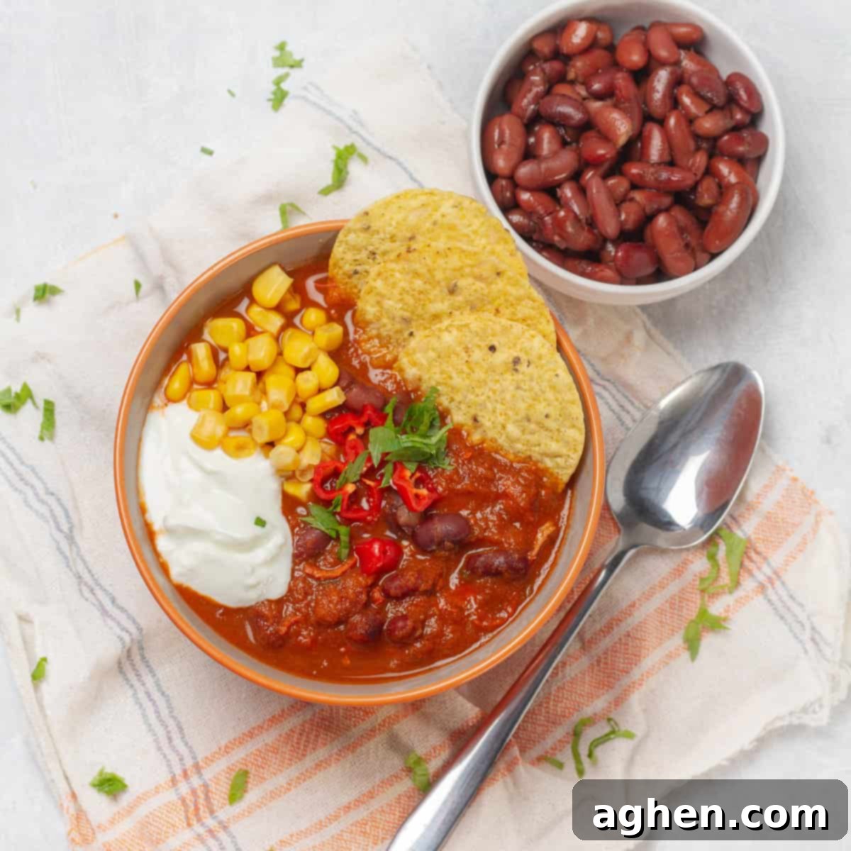 Wholesome Chicken Enchilada Soup 2 Hearty and nourishing chicken enchilada soup in a bowl, topped with crispy tortilla chips, fresh cilantro, and a dollop of sour cream.