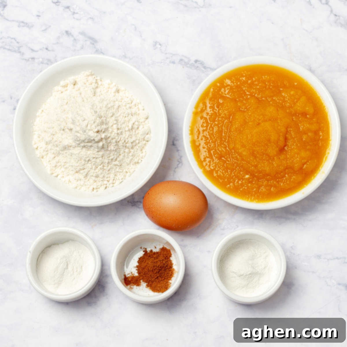 Fall Mornings Deserve These Irresistible Pumpkin Pancakes 3 Bowls of whole wheat flour, stevia, cinnamon, baking powder, pumpkin puree, and a small egg, showing the ingredients for healthy pumpkin pancakes