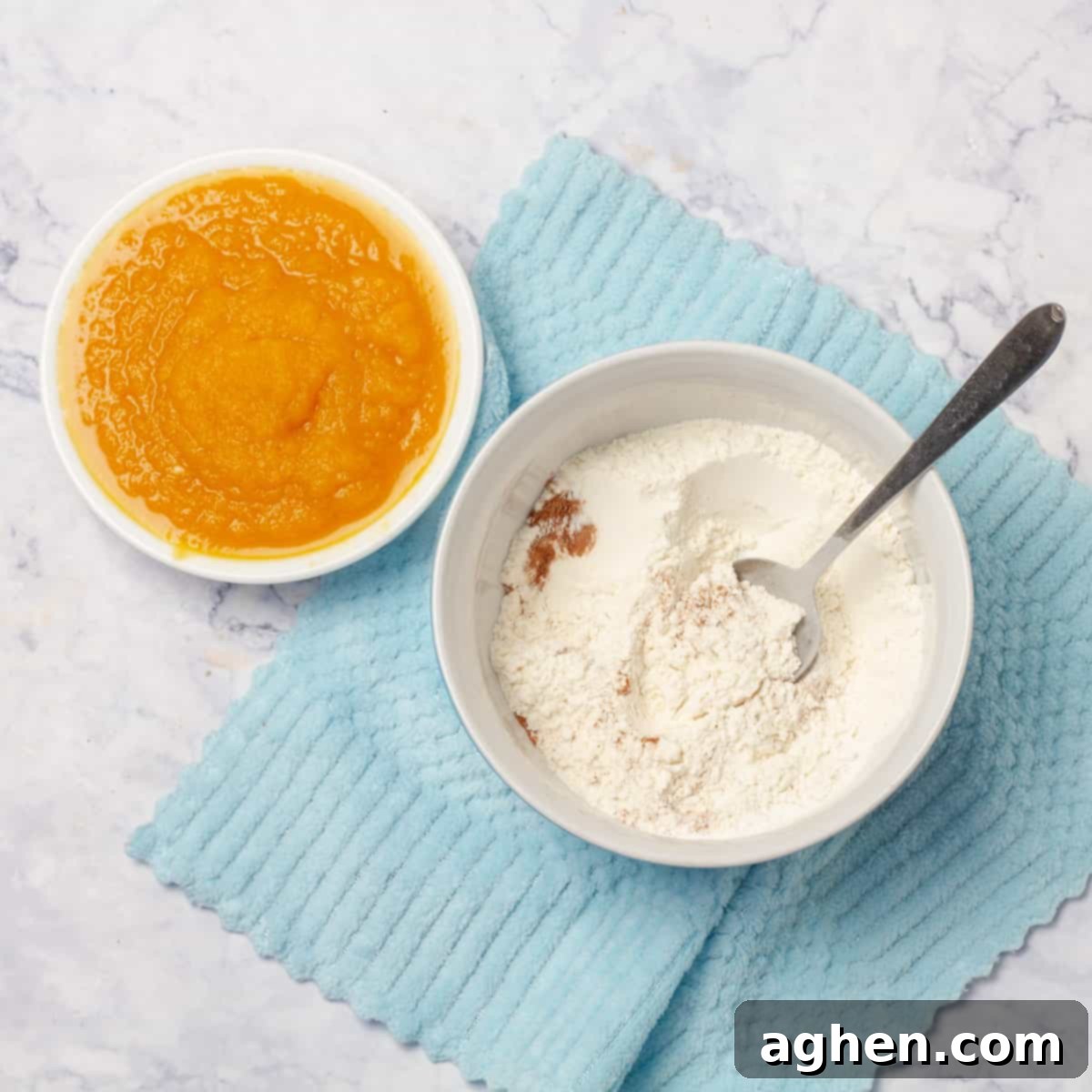Fall Mornings Deserve These Irresistible Pumpkin Pancakes 4 A large mixing bowl containing dry ingredients like whole wheat flour, stevia, cinnamon, and baking powder, alongside a smaller bowl with vibrant pumpkin puree, ready for mixing healthy pumpkin pancakes
