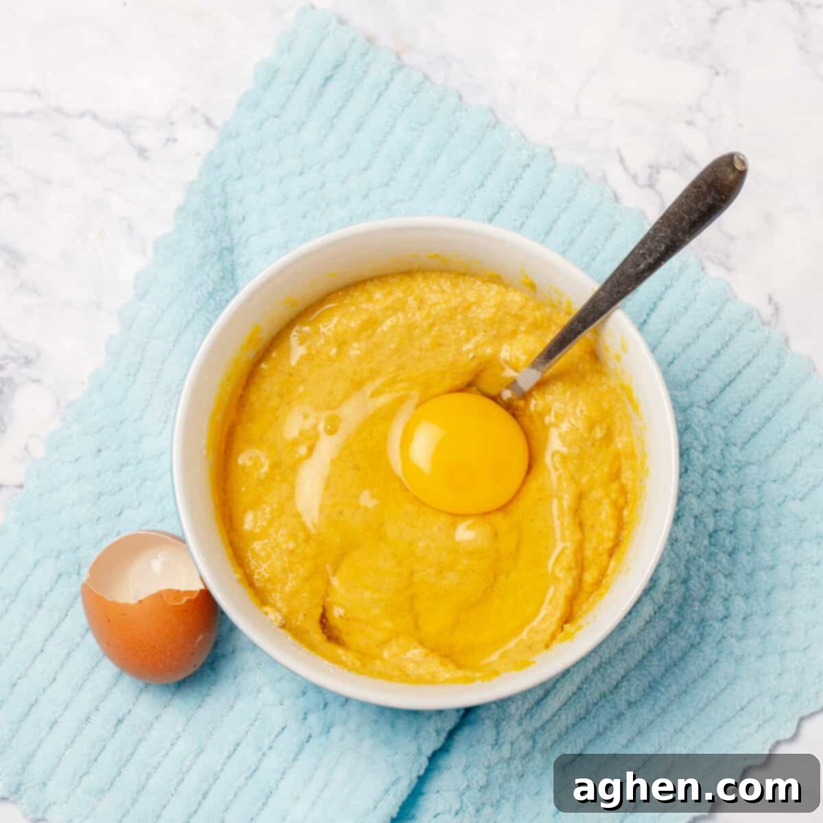Fall Mornings Deserve These Irresistible Pumpkin Pancakes 5 A bowl filled with rich orange pumpkin puree next to a single cracked egg, prepared to be mixed into the pancake batter for healthy pumpkin pancakes