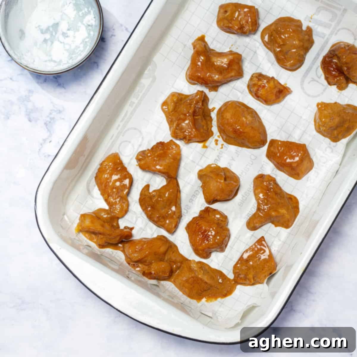 Lightened-Up Weight Watchers Orange Chicken 6 Floured chicken pieces neatly arranged on a baking tray, ready for the oven.
