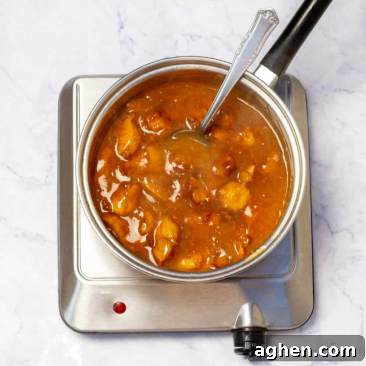 Lightened-Up Weight Watchers Orange Chicken 7 Preparing the vibrant orange sauce in a saucepan on the stove.