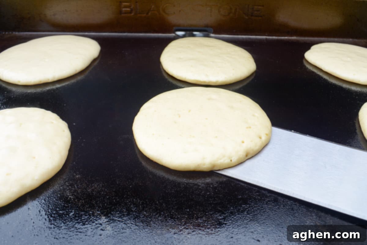 Blackstone Pancake Perfection: Your Ultimate Guide 9 spatula flipping a pancake on the blackstone