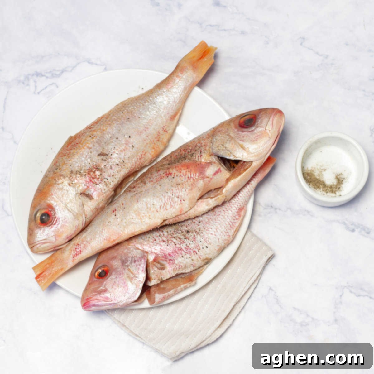 Mastering Mouthwatering Stuffed Fish 4 Cleaned fish seasoned inside with minced garlic, salt, and pepper in a baking tray