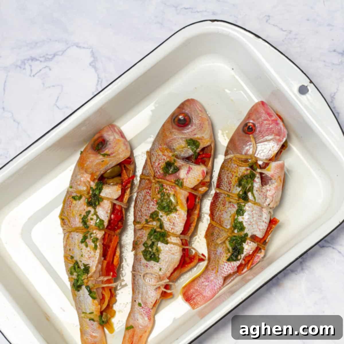 Mastering Mouthwatering Stuffed Fish 7 Three stuffed fish neatly arranged in a baking tray, ready for the oven