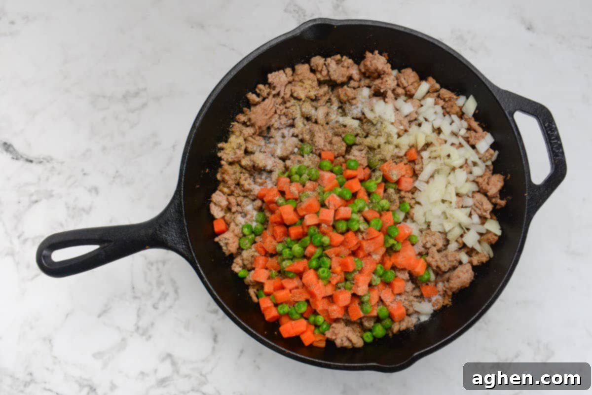 Weight Watchers' Timeless Ground Turkey Shepherd's Pie 7 A cast iron skillet with browned ground turkey and topped with vegetables and seasoning