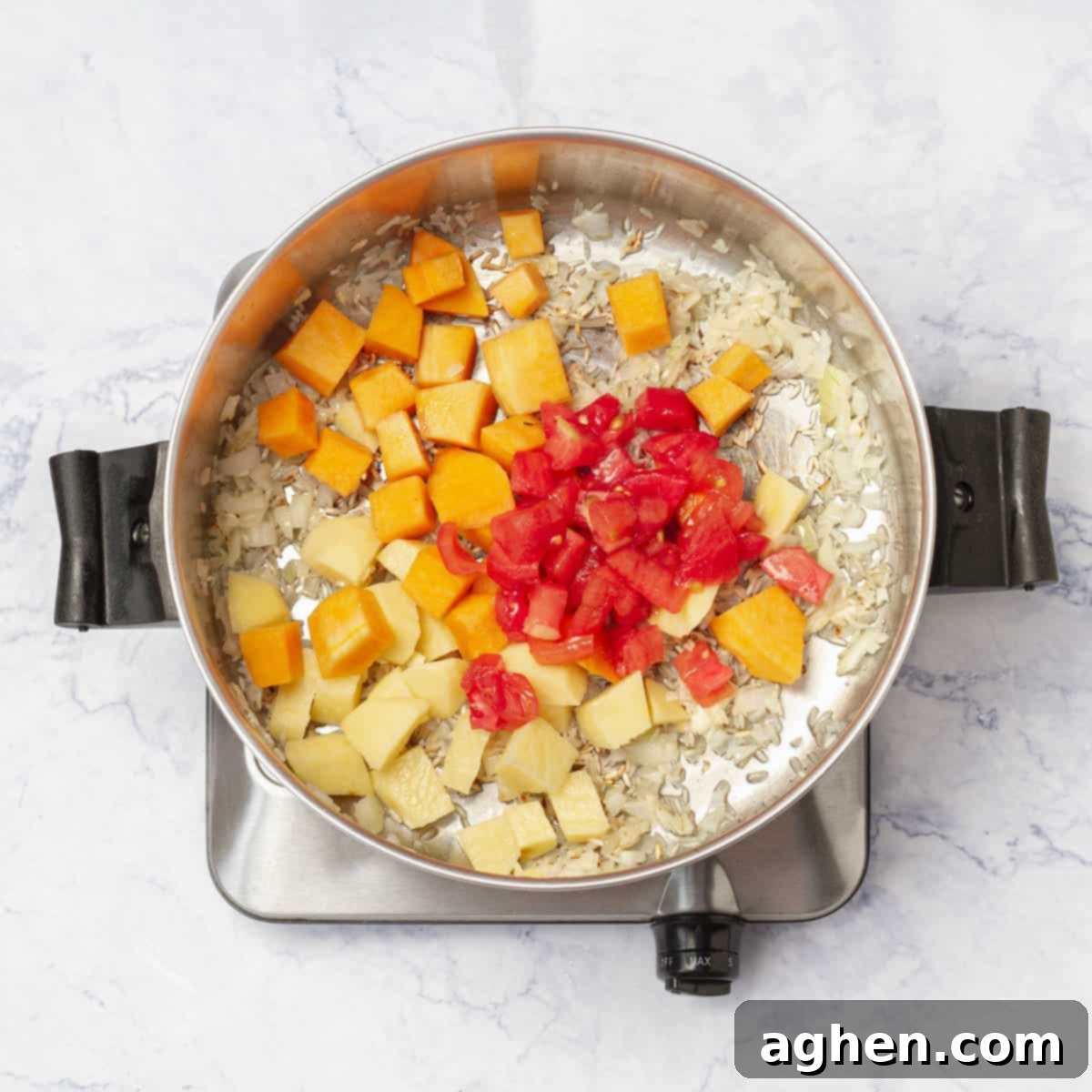 Adding diced pumpkin, potato, and tomato to the pot