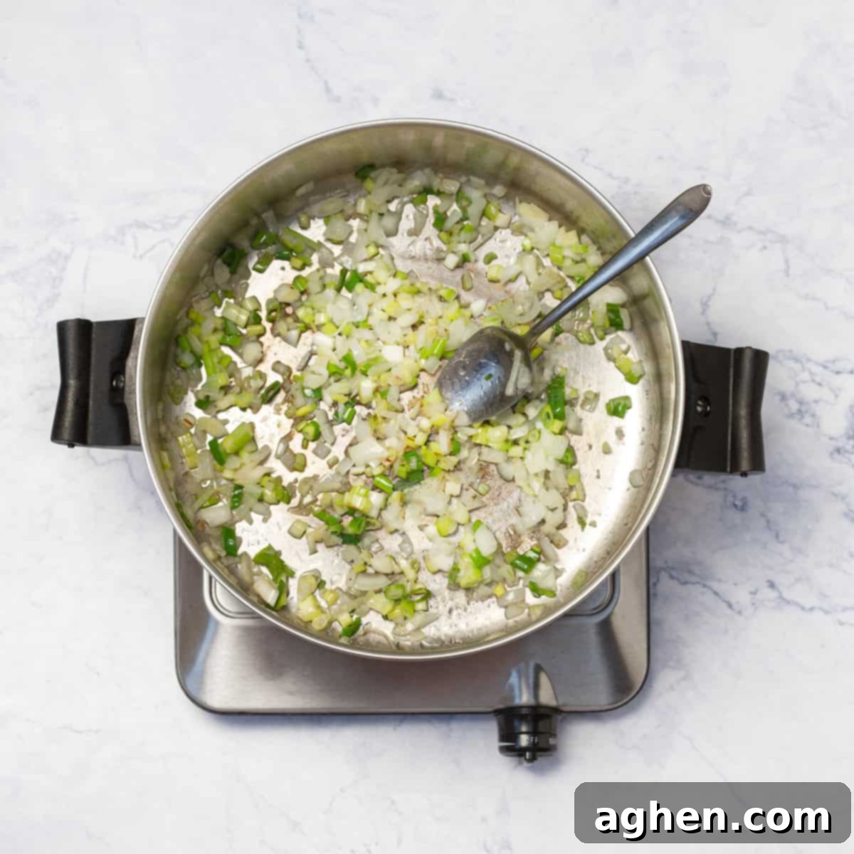 Weight Watchers Kinoa Çorbası: Lezzetli Bir Öğle Yemeği Keyfi 4 Chopped white onion, green onions, and celery sautéing in olive oil in a large pot over medium heat.
