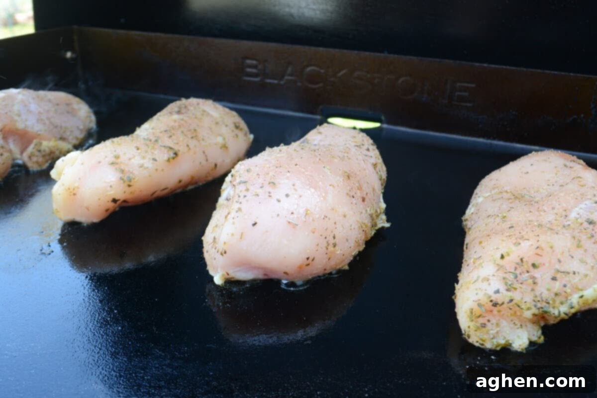 The Secret to Juicy Chicken Breasts on Your Blackstone 6 Three pieces of raw chicken breast is placed on the griddle