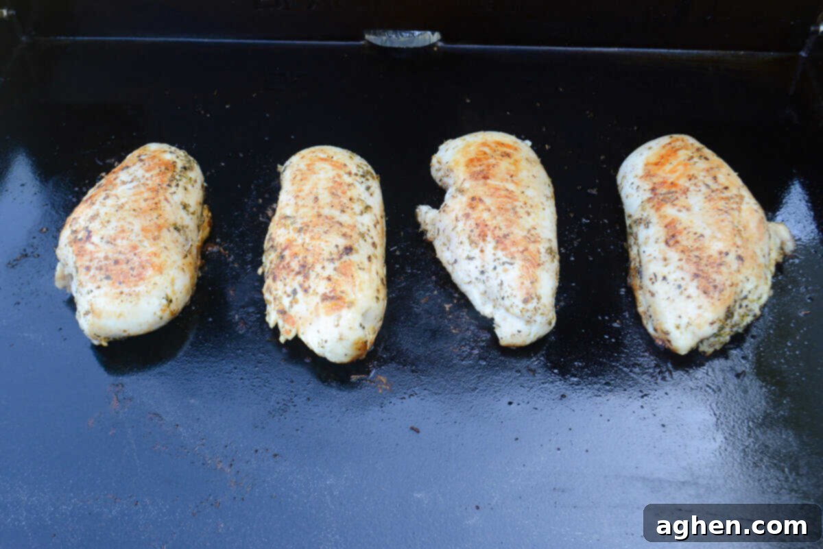 The Secret to Juicy Chicken Breasts on Your Blackstone 8 Four pieces of chicken breast are fully cooked and browned sit on top of the Blackstone griddle surface