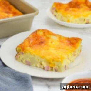 Smart Start Breakfast Bake 11 A slice of baked Weight Watchers breakfast casserole sits on a white plate. To the side is a small plate with a single slice, the baking pan, a gray napkin and a small bowl of salsa