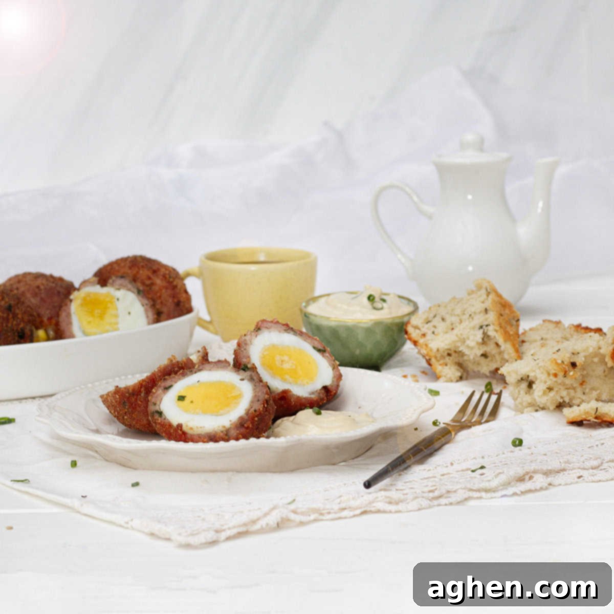 Wow Your Brunch Guests with Weight Watchers Scotch Eggs 2 Beautifully plated Air Fryer Scotch Eggs with a garnish of fresh herbs, ready to be served on a rustic wooden table.