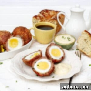 Crispy Air Fryer Scotch Eggs beautifully sliced to show a perfect creamy yolk.