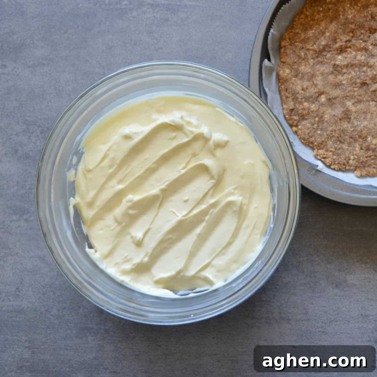 Smart Indulgence New York Cheesecake with Blueberry Compote 4 Freshly mixed cheesecake batter being poured into a golden-baked graham cracker crust, ready for the oven