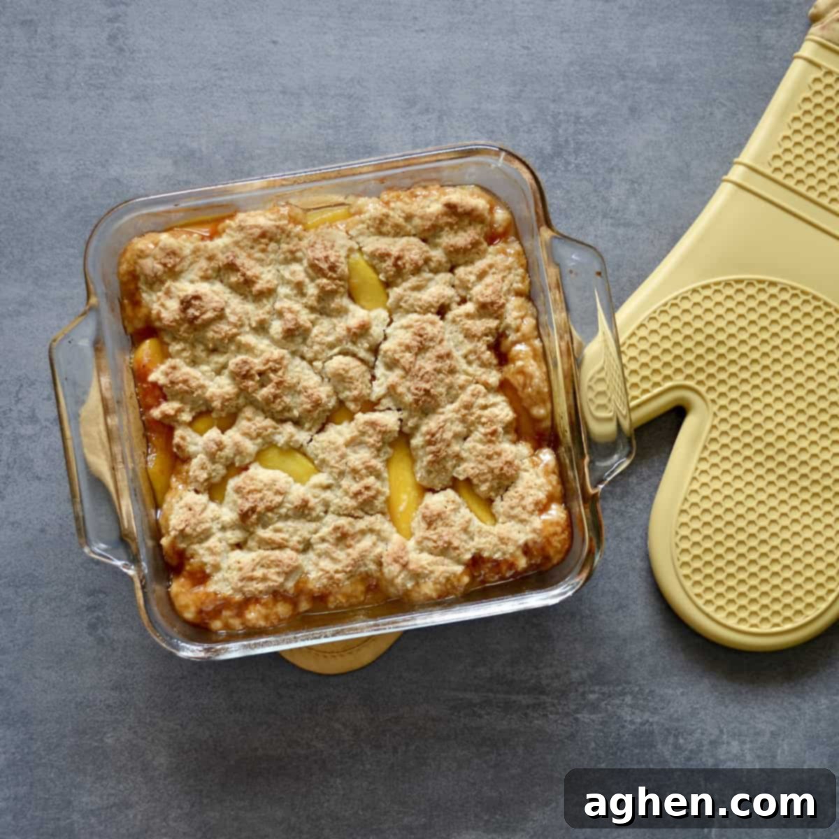 Light and Luscious Peach Cobbler 5 Baking dish with peach cobbler and oven mitt
