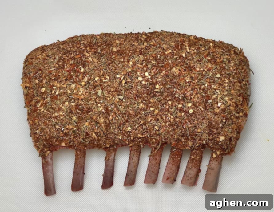 Perfectly Smoked Rack of Lamb, Surprisingly Simple 5 Lamb rub being applied over Dijon mustard on rack of lamb