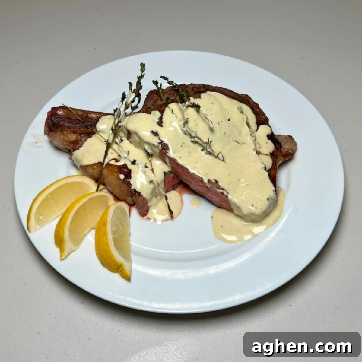 Mükemmel Biftek: Döküm Tavada Pişirmenin Püf Noktaları 14 Slices of ribeye steak with creamy mustard sauce on a white plate.