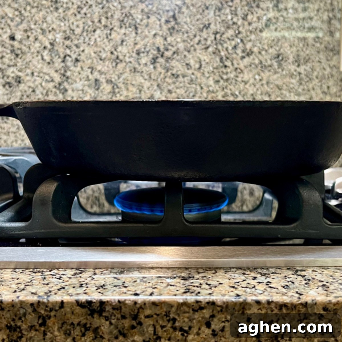 Mükemmel Biftek: Döküm Tavada Pişirmenin Püf Noktaları 7 A stovetop burner set to a low flame, heating a cast iron skillet.